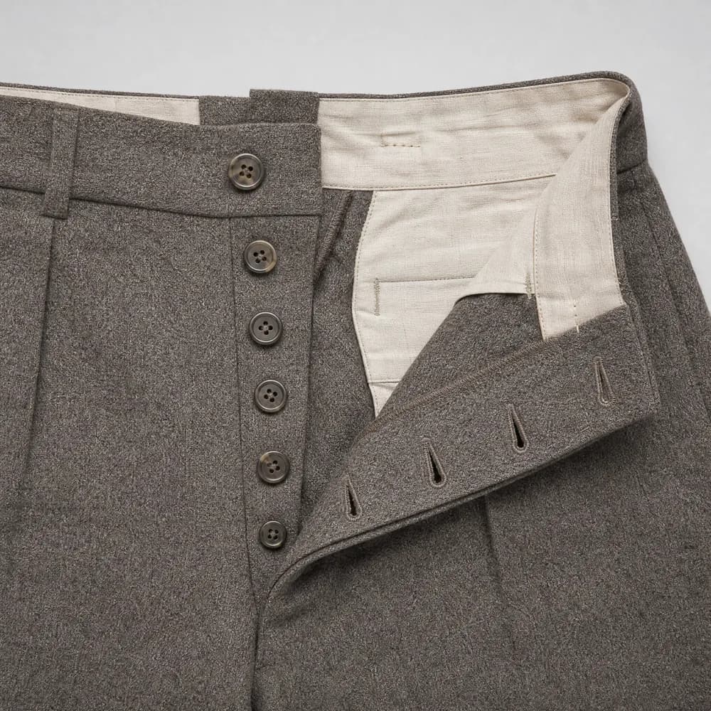 A button fly opened flat, showing five buttons and the worked buttonholes opposite.