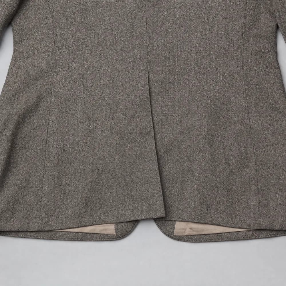 The back hem of a jacket laid flat showing a single centre vent.
