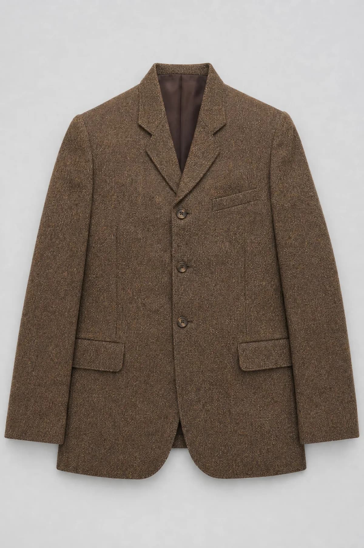 A three-button brown tweed lounge jacket laid flat with high narrow lapels.