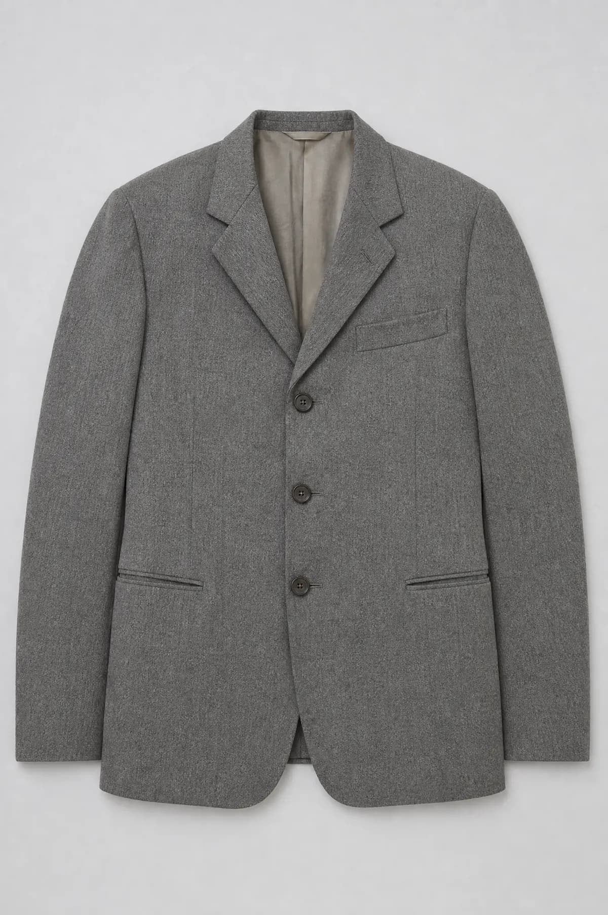 A slim grey worsted jacket laid flat with a narrow chest and straight hips.