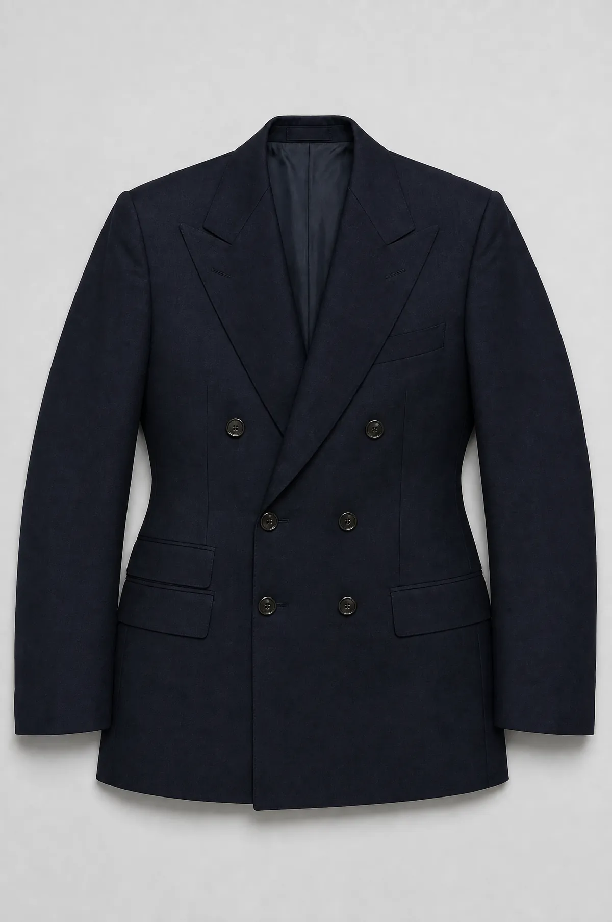 A navy double-breasted jacket laid flat with broad peaked lapels and a suppressed waist.