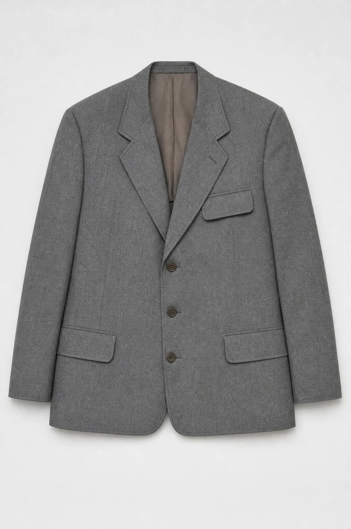 A plain grey utility suit jacket laid flat with square shoulders and wide notched lapels.