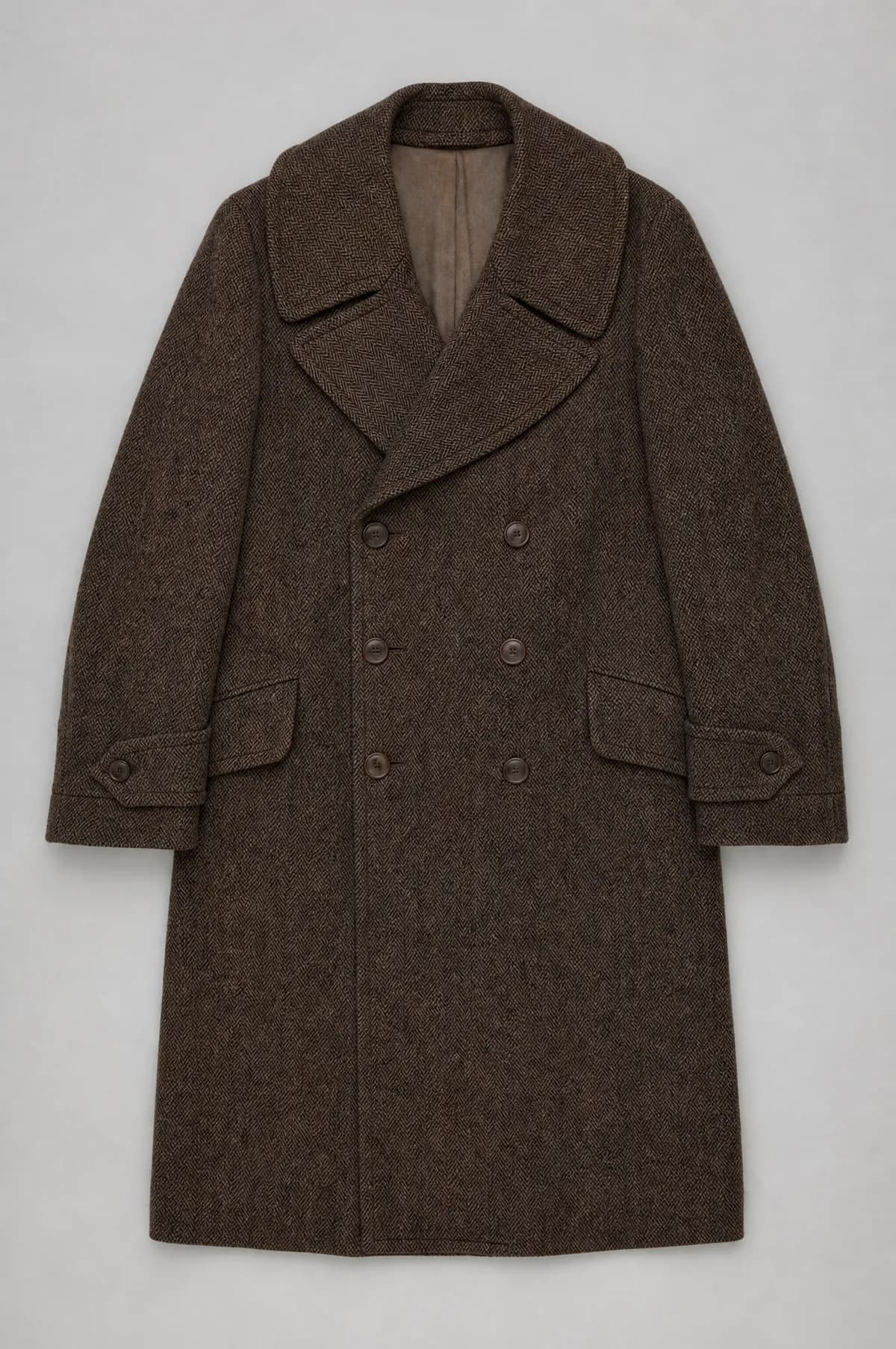 A brown herringbone ulster overcoat laid flat, double breasted with a broad storm collar.
