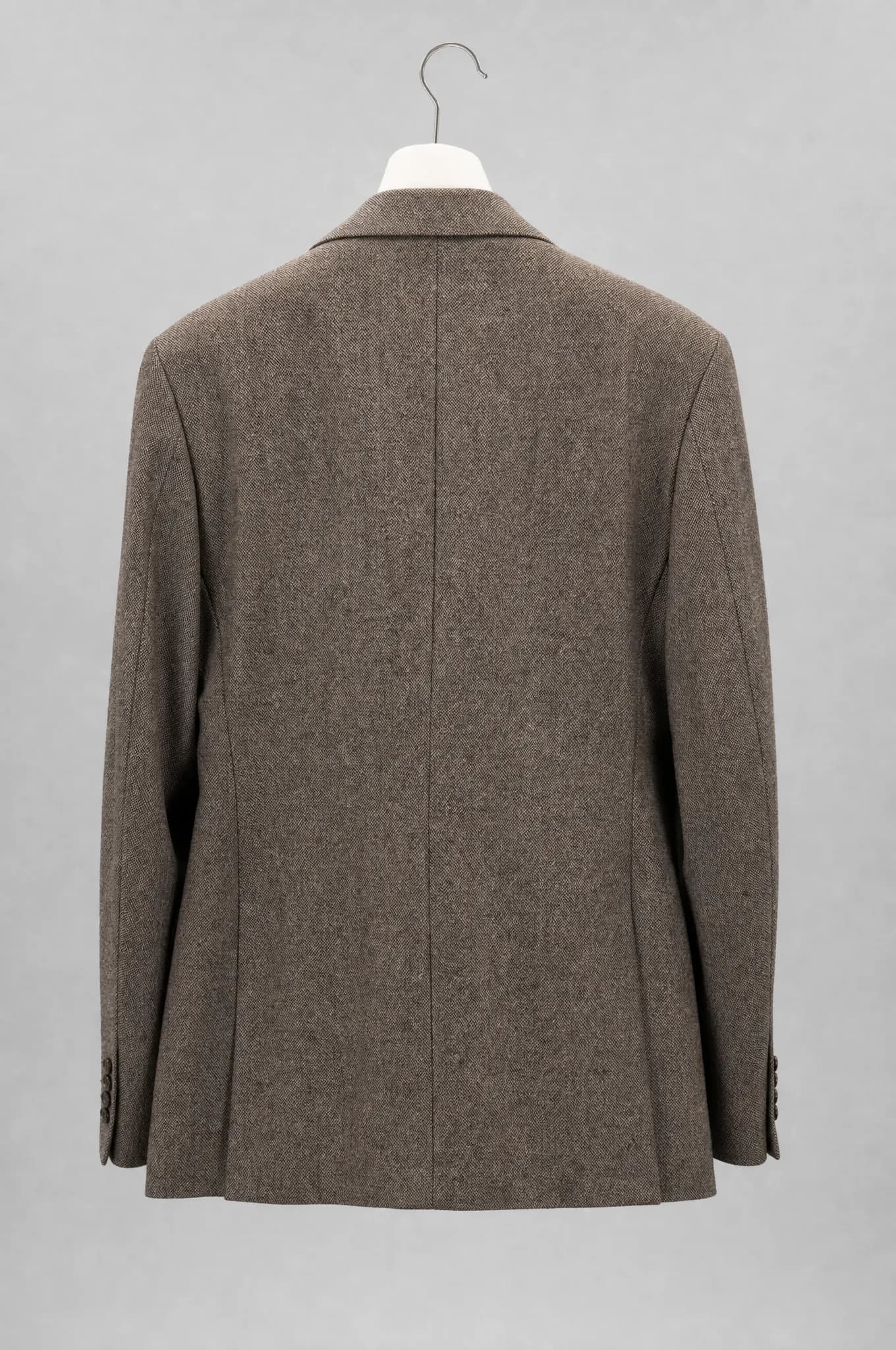 A tailored jacket seen from the back on a plain padded archive hanger.